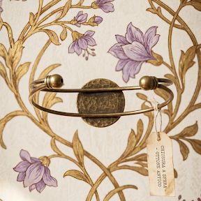 Bracciale artigianale Fildisogno con simbolo ricamato, dettagli raffinati e lavorazione artistica, visibile in primo piano.
