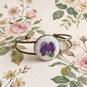 Bracciale Fildisogno con simbolo ricamato artigianale in tessuto colorato e dettagli intricati, stile elegante e unico.