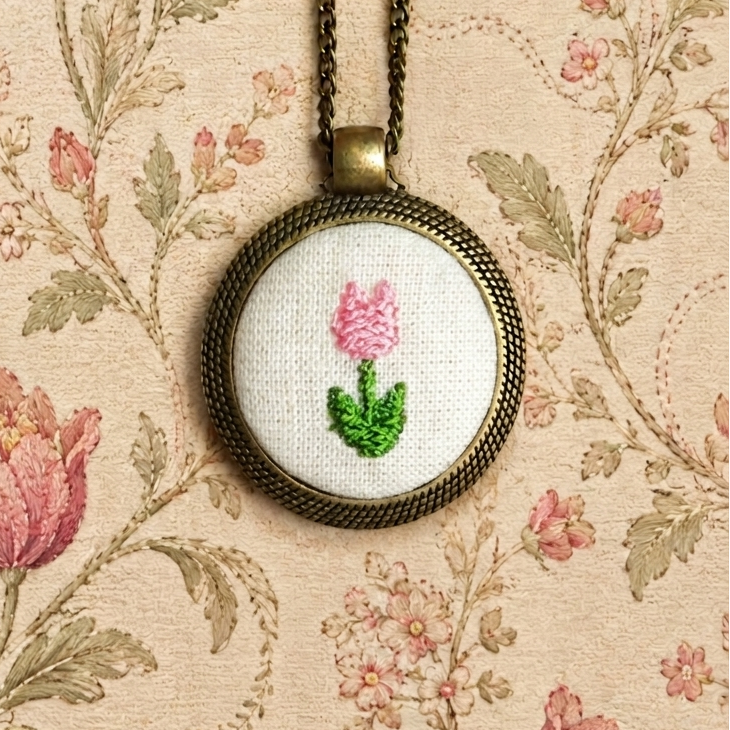 Collana artigianale Fildisogno con simbolo ricamato, dettaglio di gioielleria elegante e artigianale italiana.