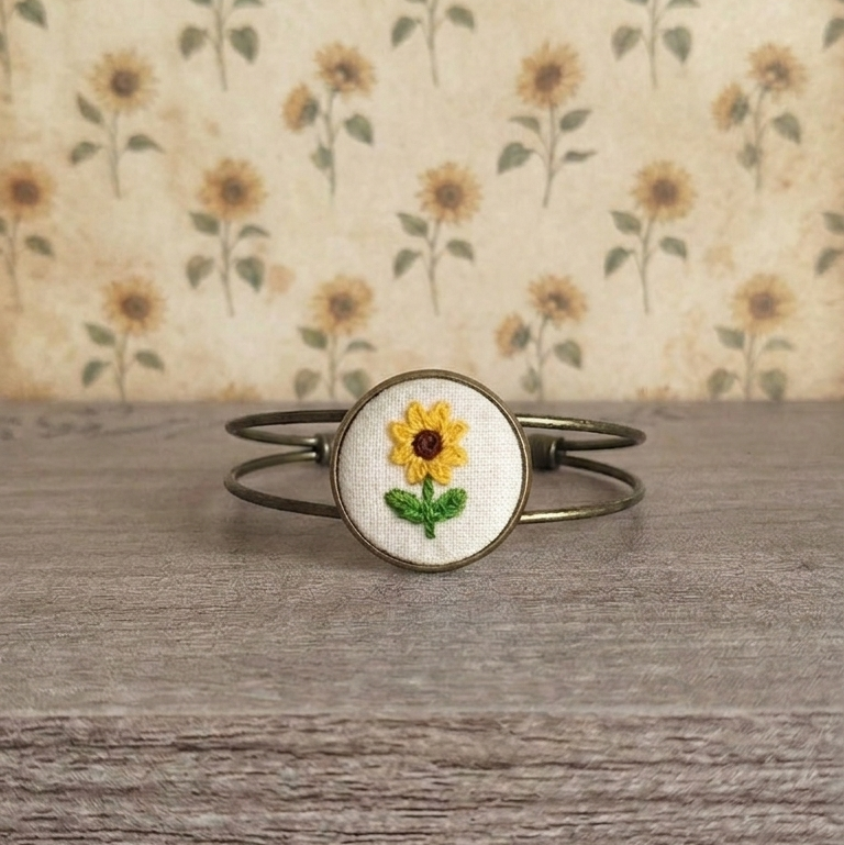 Bracciale artigianale Fildisogno con simbolo ricamato, dettaglio di tessitura e design unico, in materiali naturali e di alta qualità.