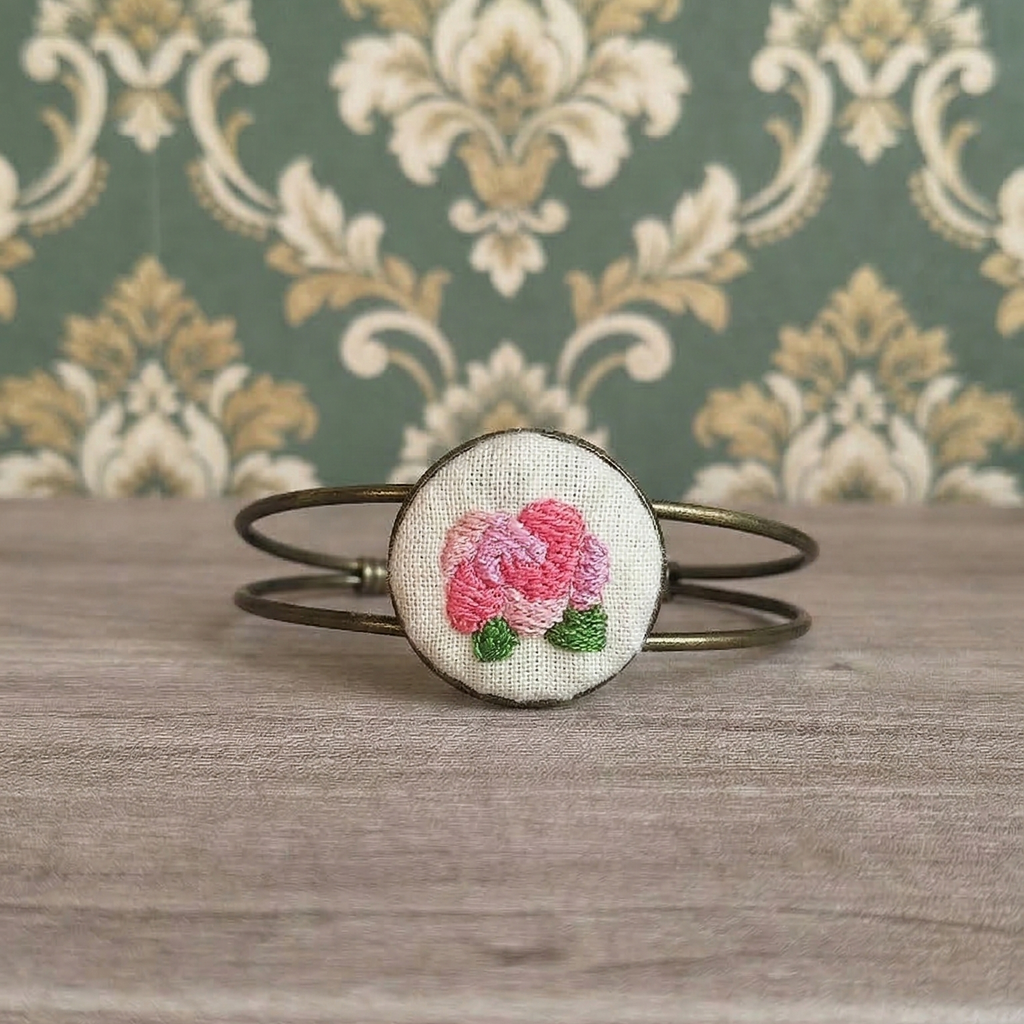 Bracciale artigianale Fildisogno con simbolo ricamato, dettagli raffinati e design unico in tessuto colorato.