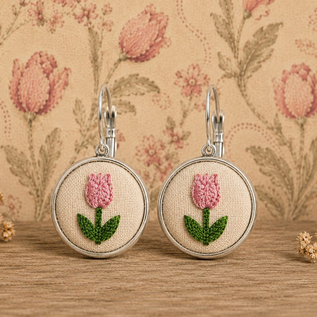 Orecchini artigianali con simbolo ricamato, realizzati a mano da Fildisogno, con dettagli ricamati eleganti e naturali.
