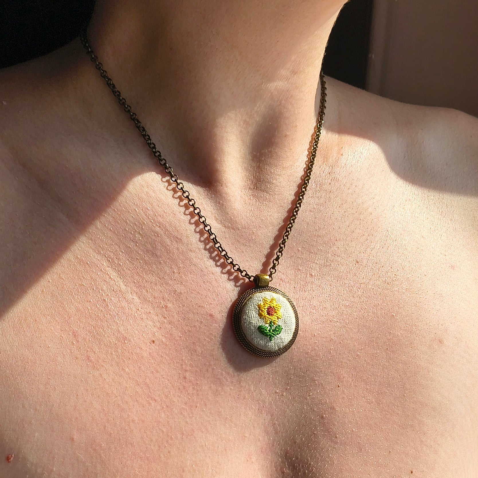 Collana artigianale Fildisogno con simbolo ricamato, dettagli raffinati e lavorazione fatta a mano, indossata su sfondo neutro.