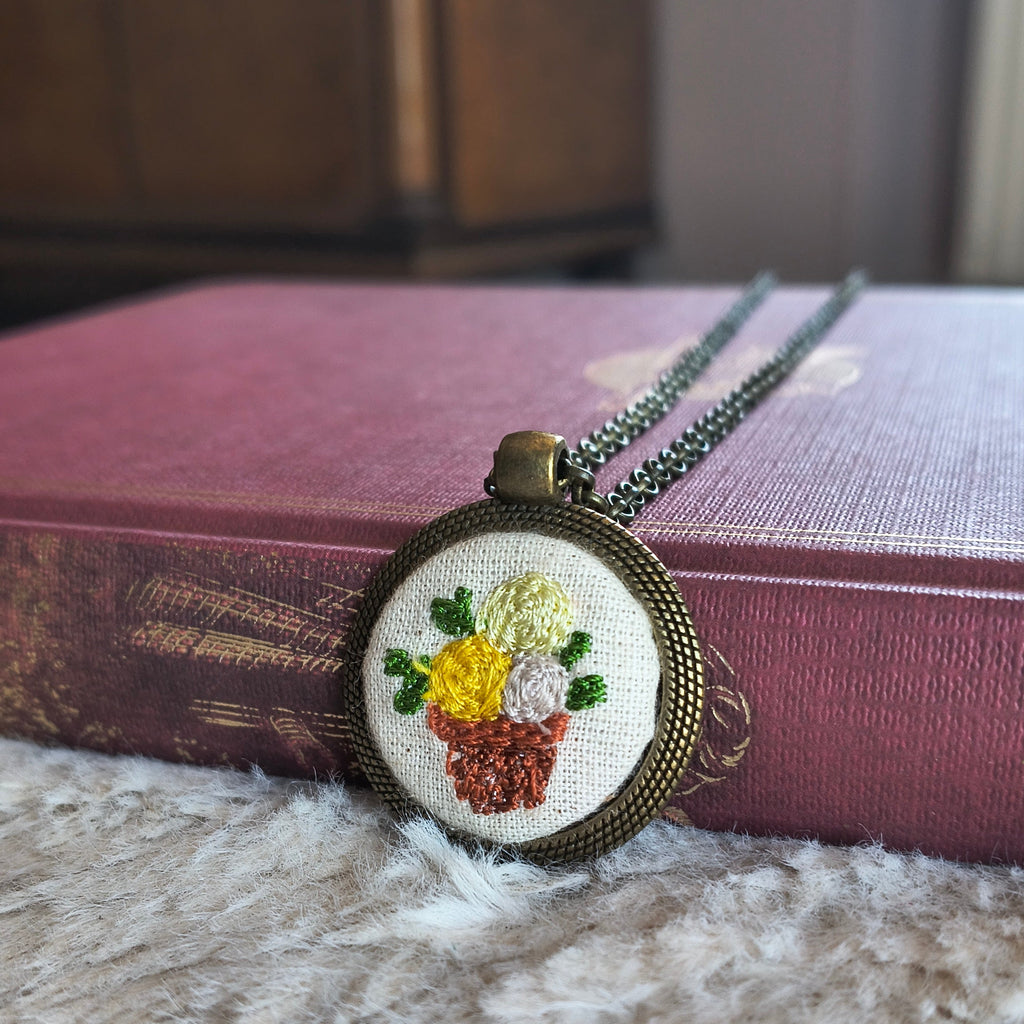 Collana artigianale Fildisogno con simbolo ricamato, dettaglio elegante e fatto a mano, visibile in primo piano.