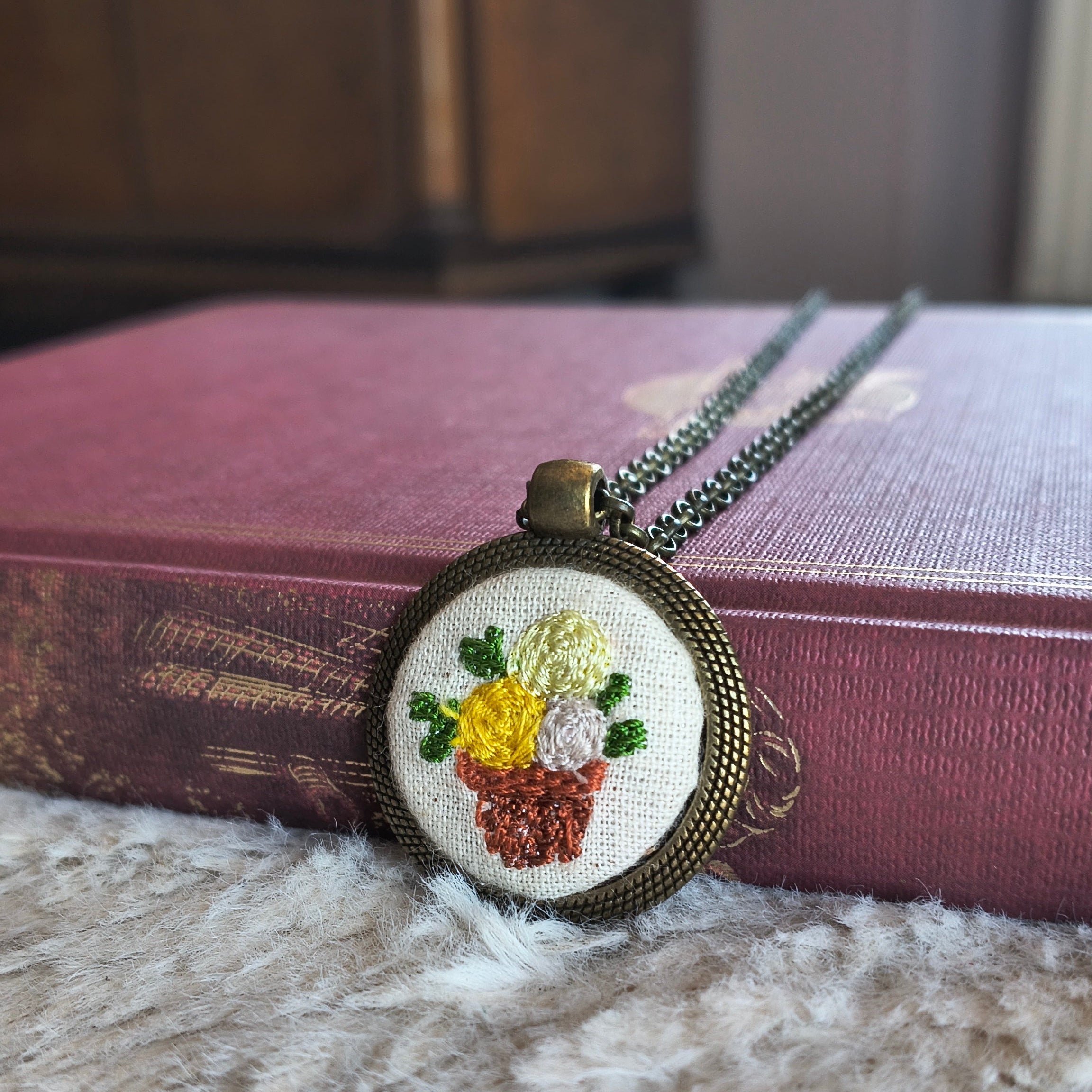 Collana artigianale Fildisogno con simbolo ricamato, dettaglio elegante e fatto a mano, visibile in primo piano.