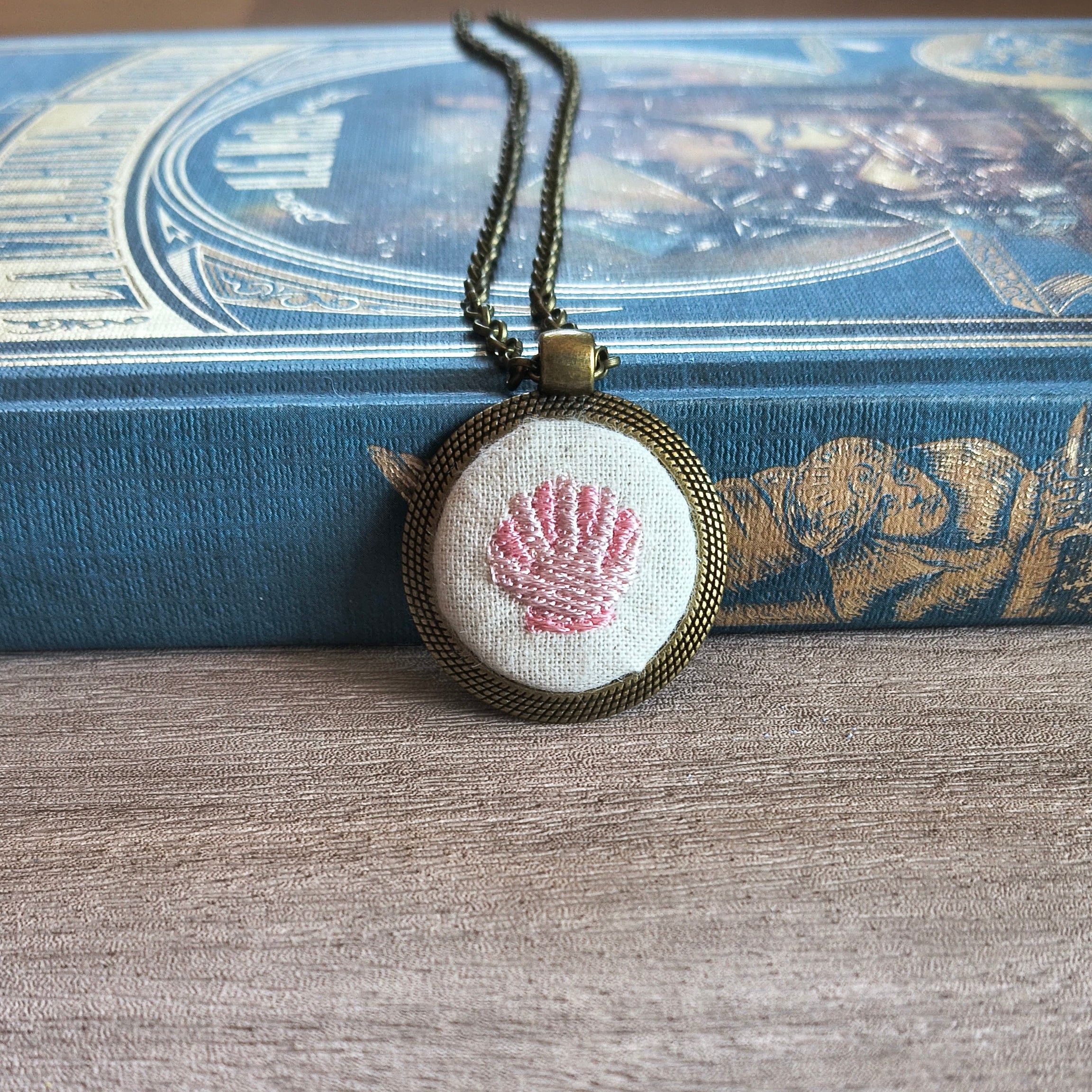 Collana artigianale Fildisogno con simbolo ricamato, dettaglio elegante e fatto a mano, visibile in primo piano.