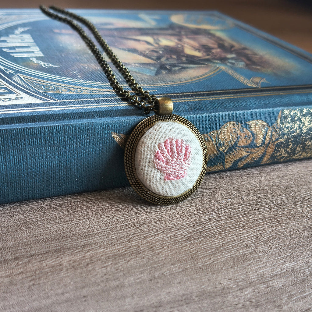 Collana artigianale con simbolo ricamato, realizzata a mano da Fildisogno, con dettagli ricamati visibili in primo piano