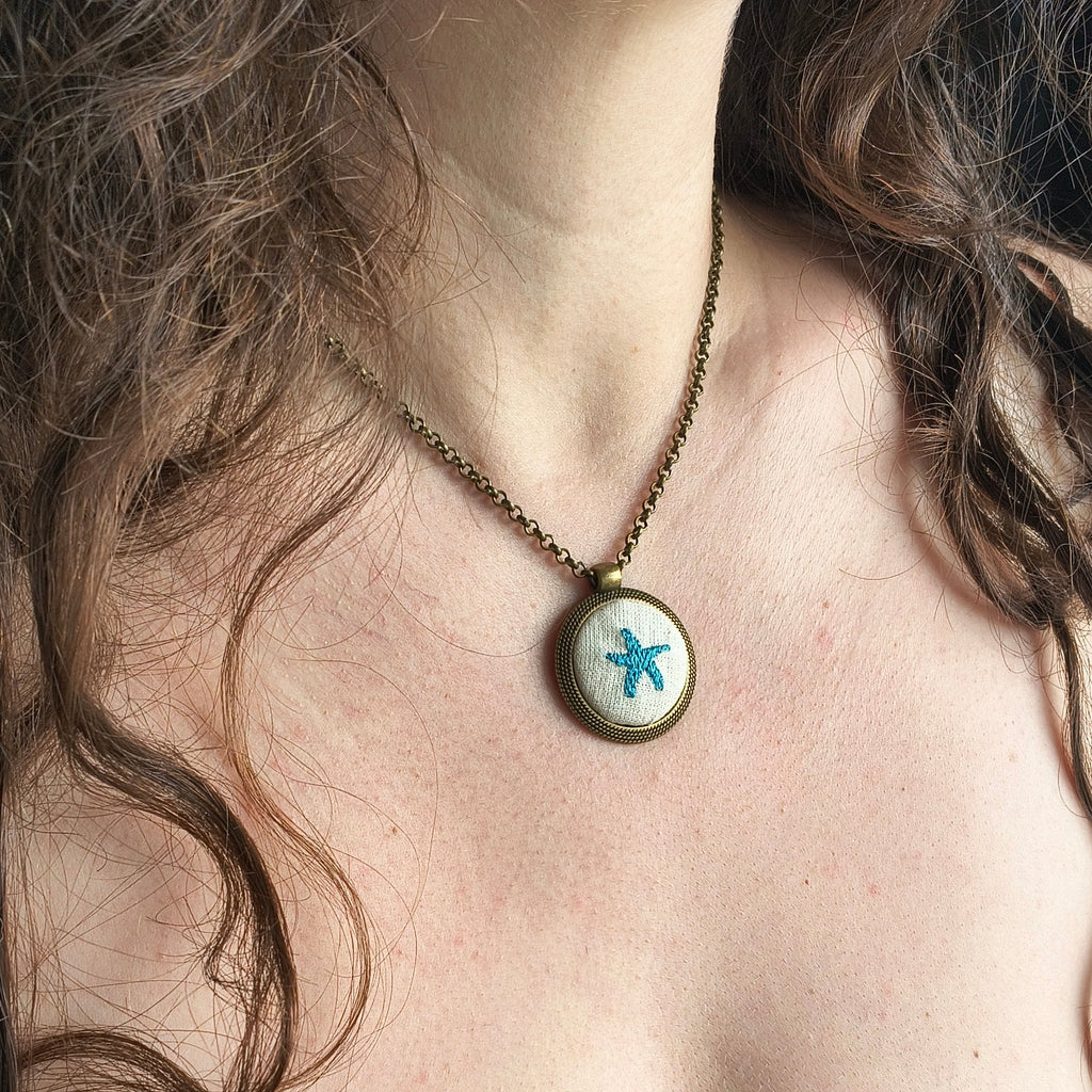 Collana artigianale Fildisogno con simbolo ricamato, dettagli raffinati e design unico, visibile nell'immagine.