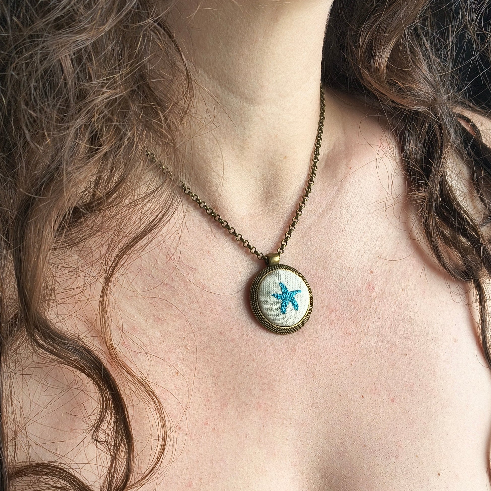 Collana artigianale Fildisogno con simbolo ricamato, dettagli raffinati e design unico, visibile nell'immagine.