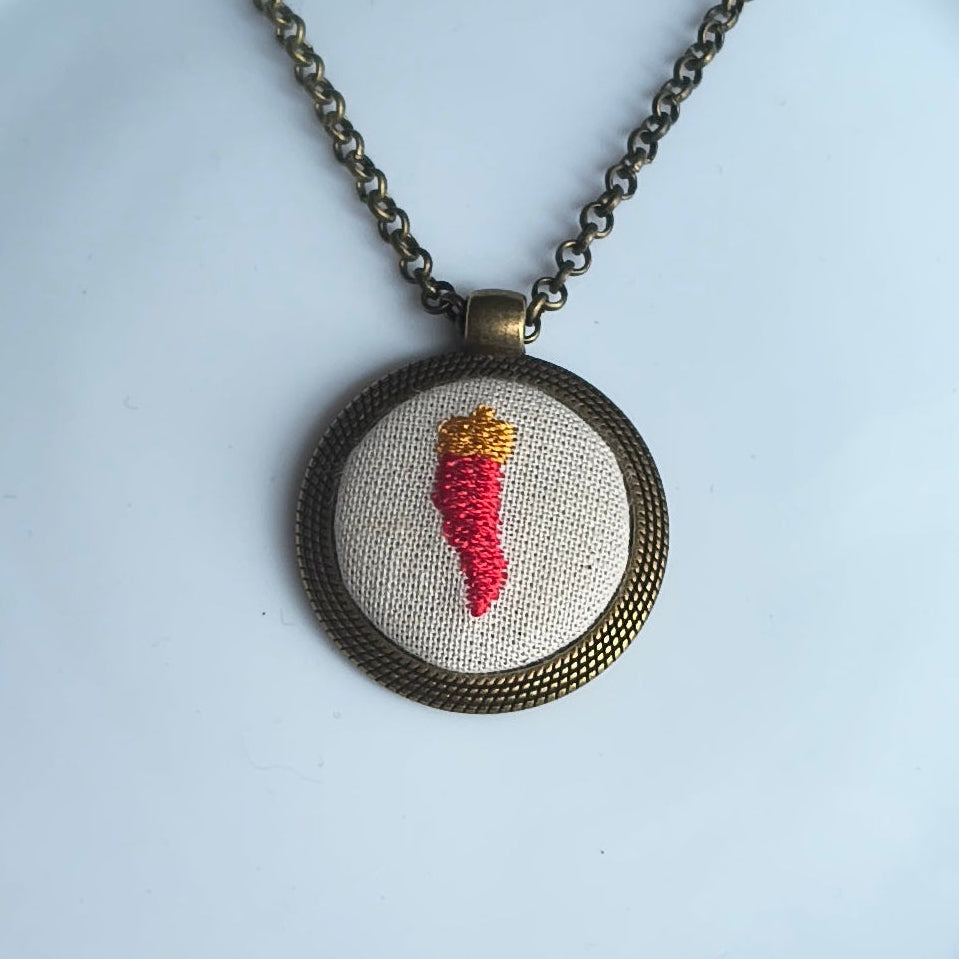 Collana artigianale Fildisogno con simbolo ricamato, dettagli raffinati e lavorazione artigianale, mostra il simbolo ricamato in primo piano.