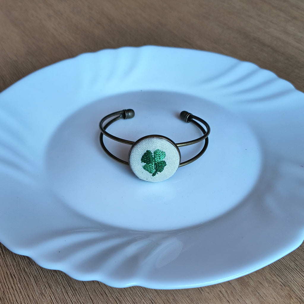 Bracciale artigianale Fildisogno con simbolo ricamato, dettagli raffinati e finiture eleganti, visibile in primo piano.
