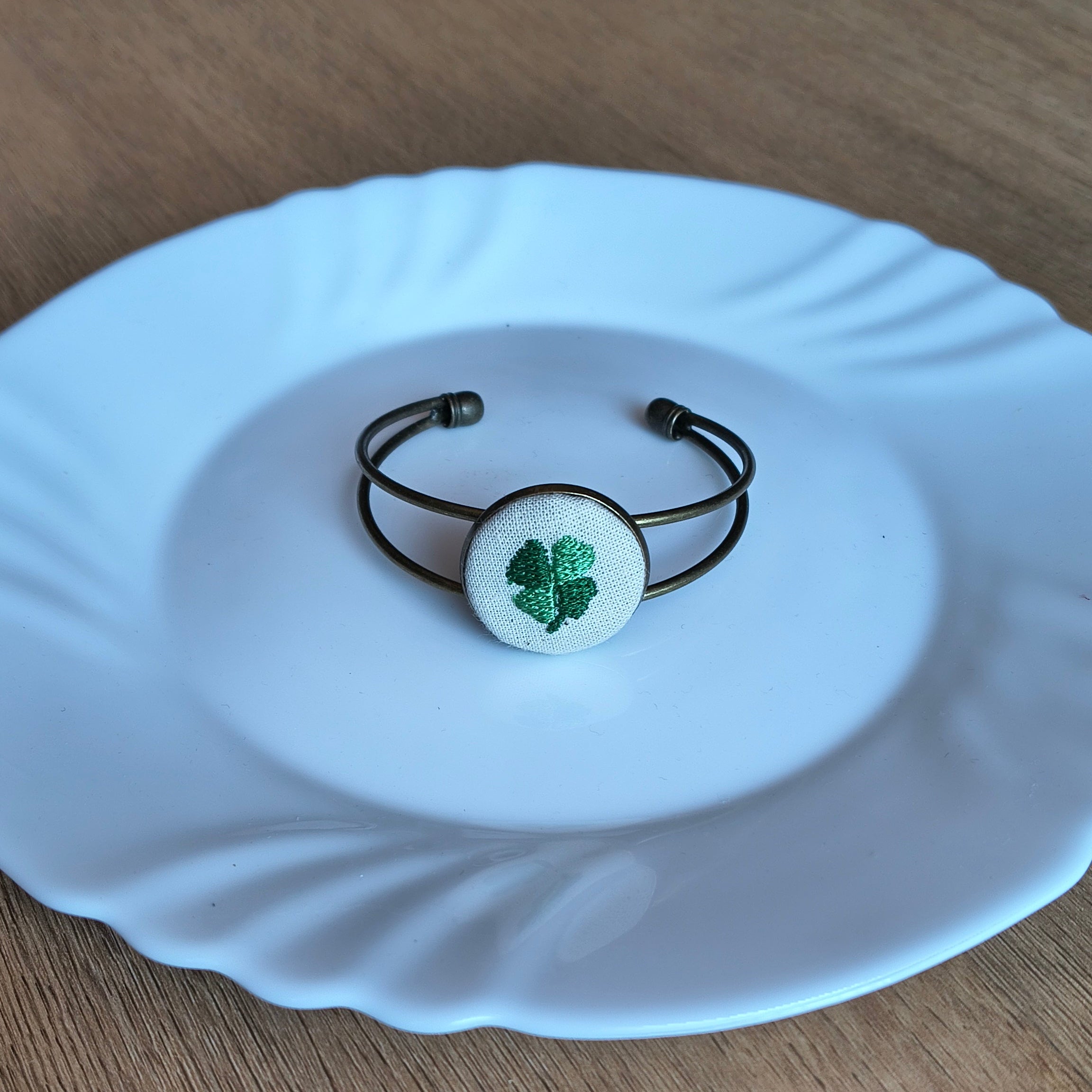 Bracciale artigianale Fildisogno con simbolo ricamato, dettagli raffinati e finiture eleganti, visibile in primo piano.