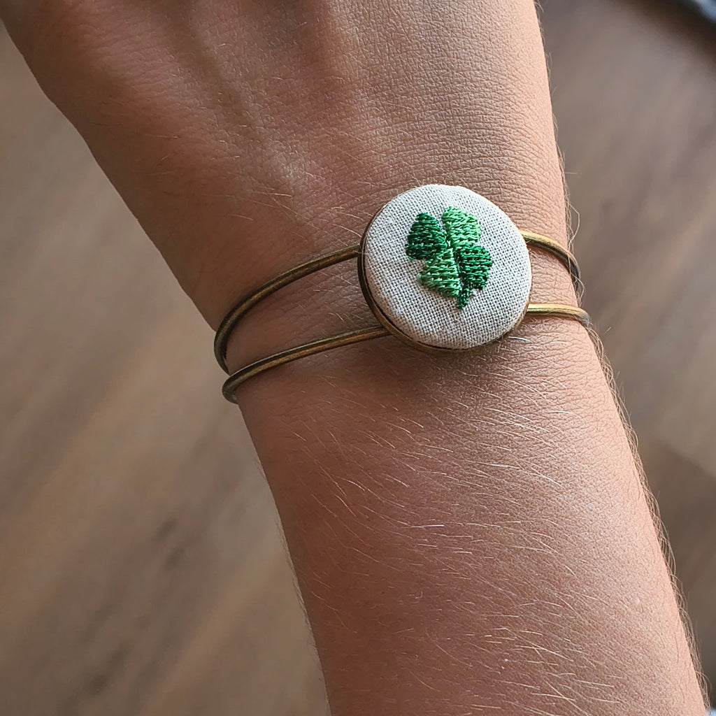 Bracciale artigianale Fildisogno con simbolo ricamato, dettagli raffinati e lavorazione a mano in tessuto colorato.