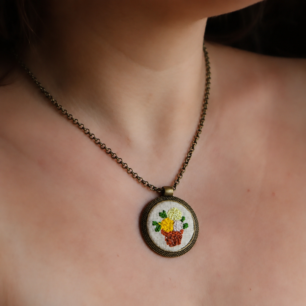 Collana artigianale Fildisogno con simbolo ricamato, dettaglio elegante e fatto a mano, in tessuto e materiali di alta qualità.